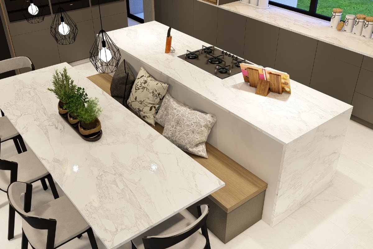 Modern kitchen featuring a large central island with integrated gas hob, stone countertops, and an attached dining bench area.