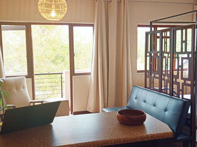 Open plan living and sleeping area featuring tiled floors and direct access to a private balcony through sliding glass doors.