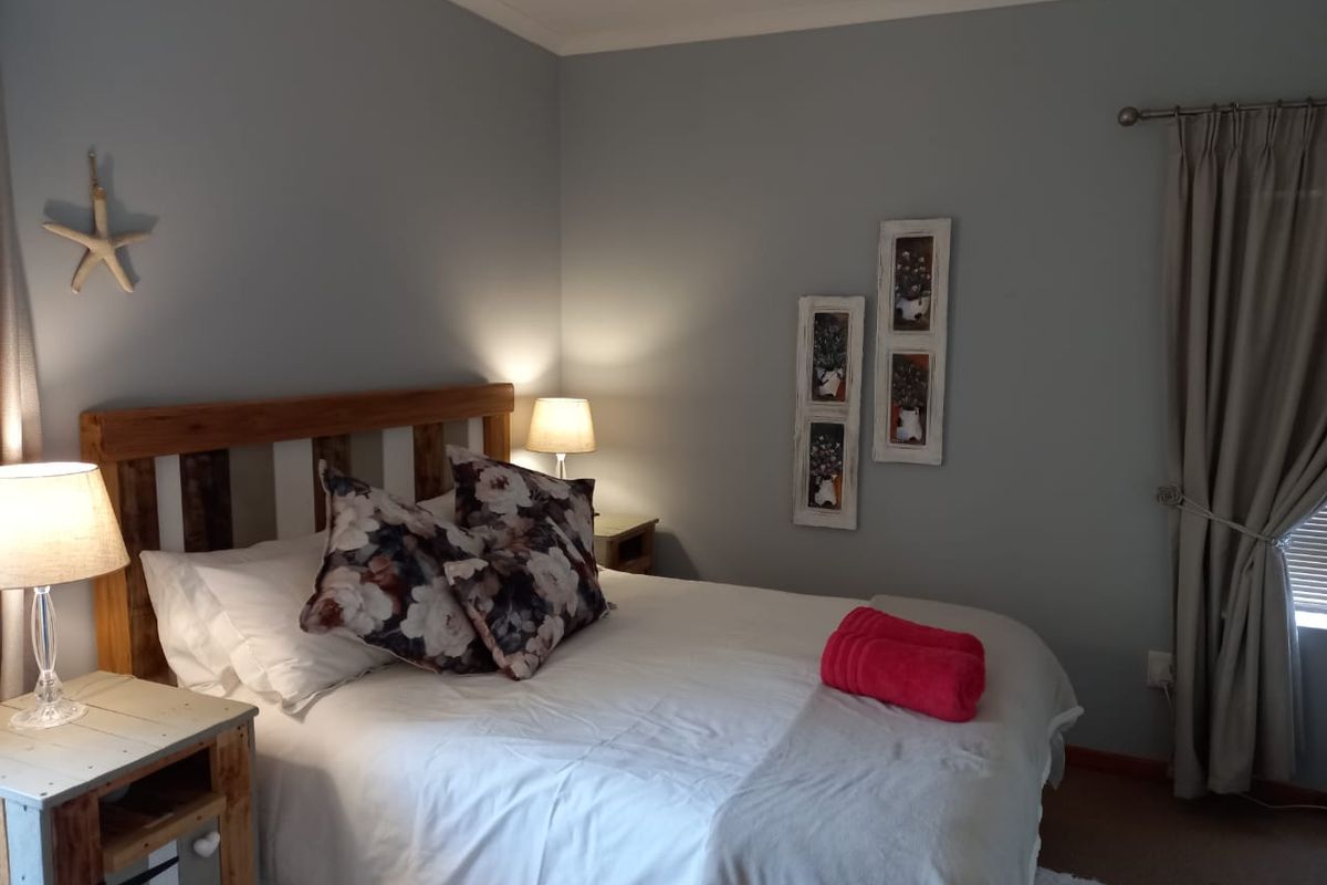 A well-maintained bedroom featuring neutral wall tones, coving, and a curtain rod, providing a comfortable and functional sleeping space.