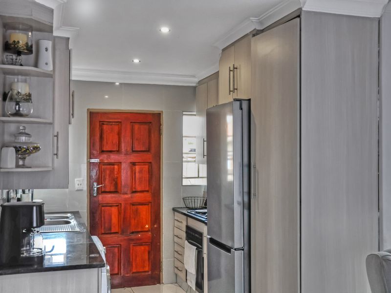 A functional kitchen featuring modern grey cabinetry, granite countertops, built-in oven, and recessed lighting, providing a clean and efficient workspace.