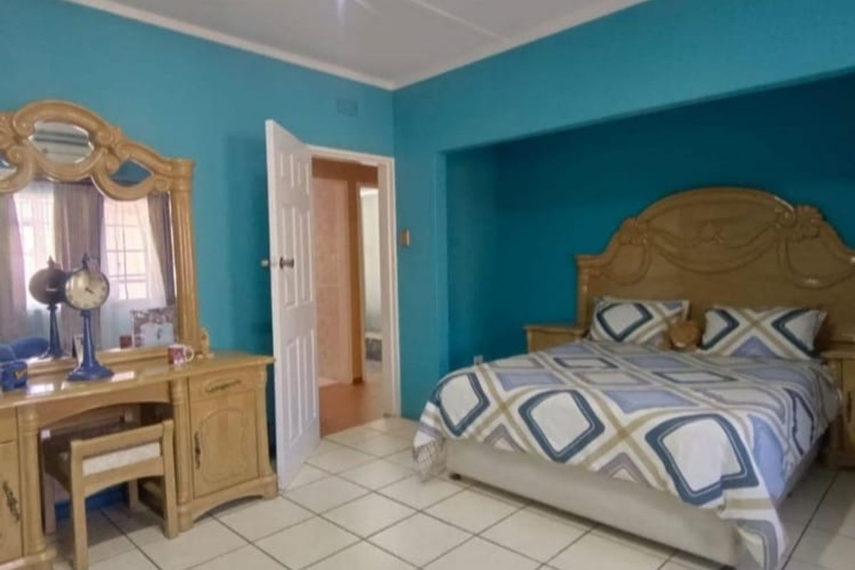 A bedroom featuring tiled flooring, recessed ceiling lighting, and a recessed bed alcove area.
