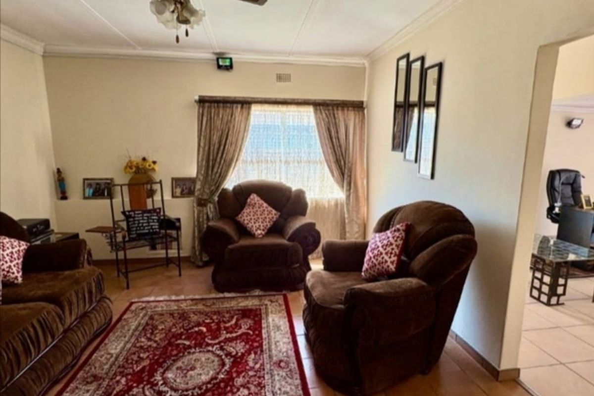A living room featuring tiled flooring, a ceiling fan, and neutral wall finishes, providing a functional and comfortable space.