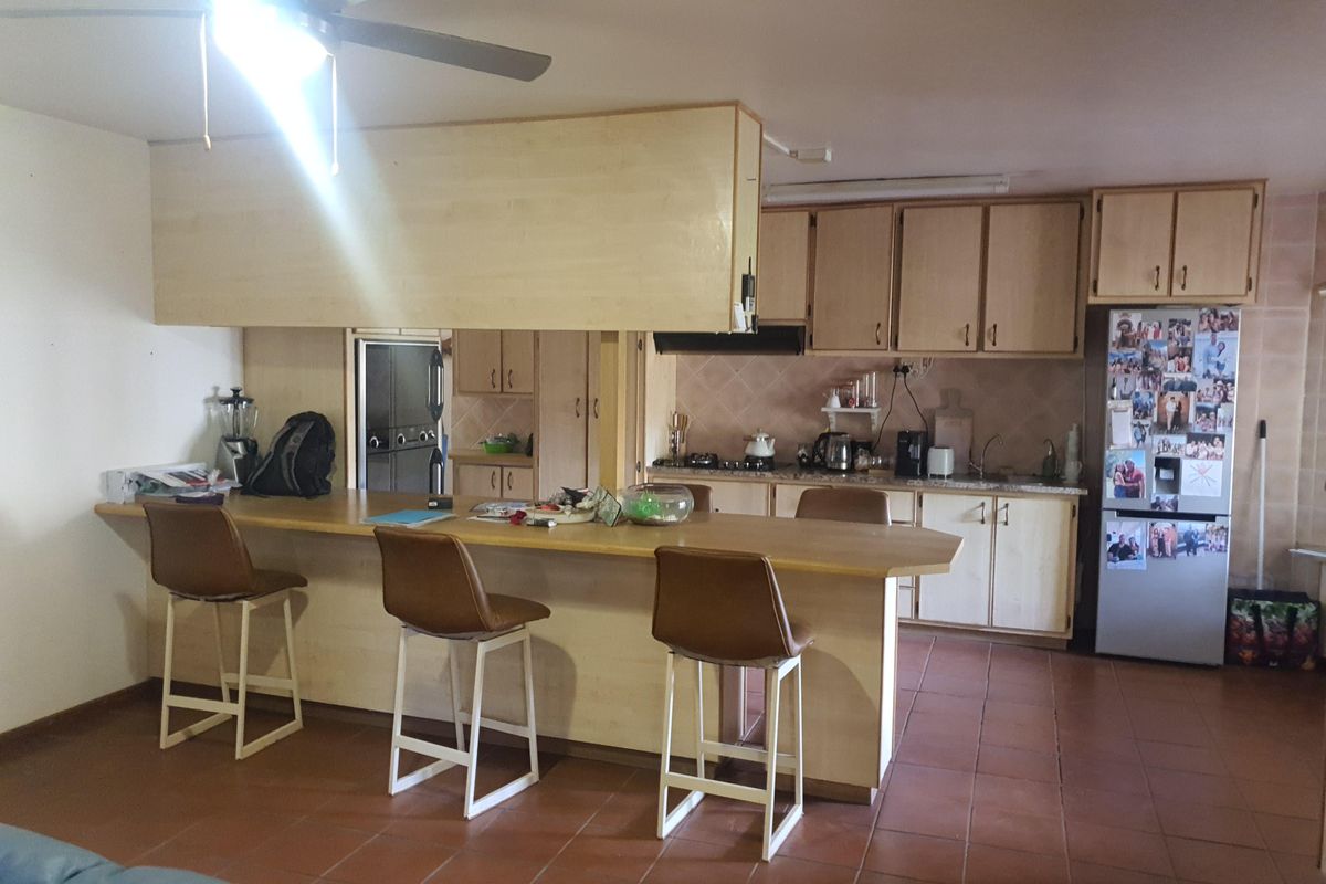 A functional kitchen featuring a breakfast bar, built-in cabinetry, and tiled flooring, offering a practical layout for daily use.