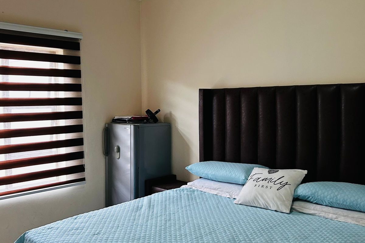 A bedroom featuring neutral walls, crown molding, and modern zebra blinds, providing a functional space for rest.