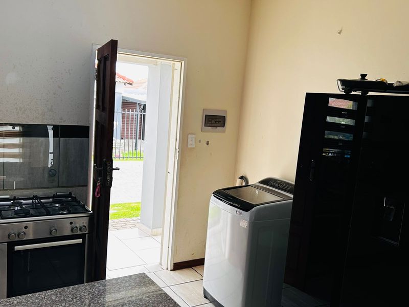 Kitchen area featuring a gas stove, granite countertops, and tiled flooring, with direct access to the exterior.