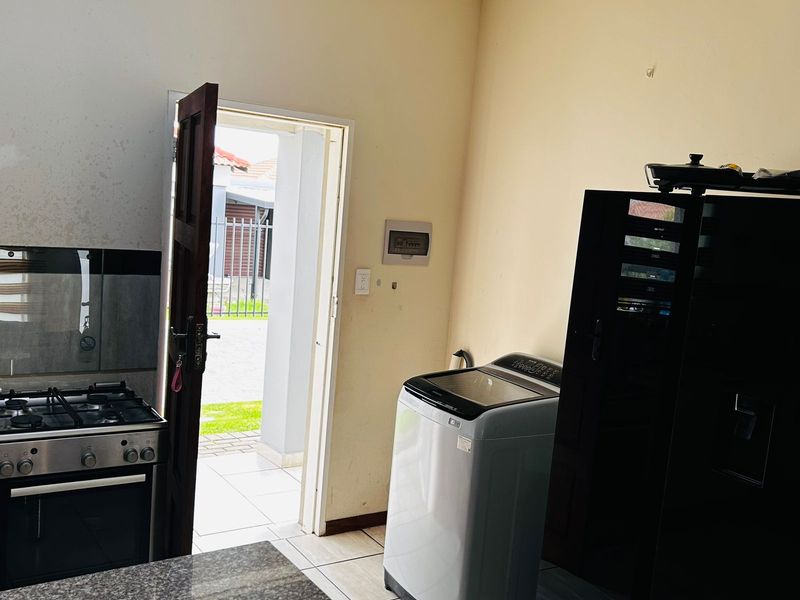 Kitchen area featuring a gas stove, granite countertops, and tiled flooring, with direct access to the exterior through a side door.