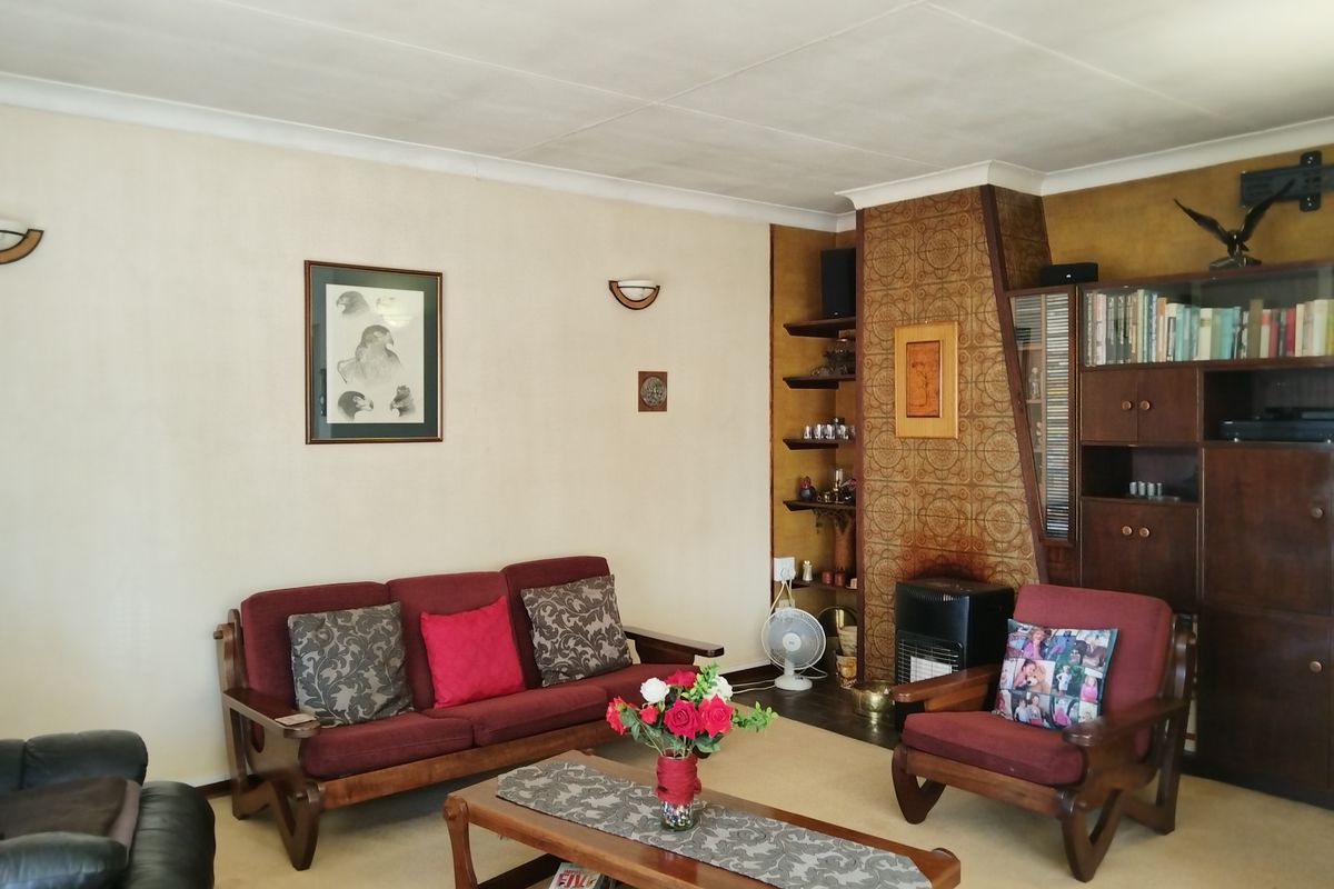 A traditional living room featuring a built-in fireplace with decorative tiling and integrated shelving units.