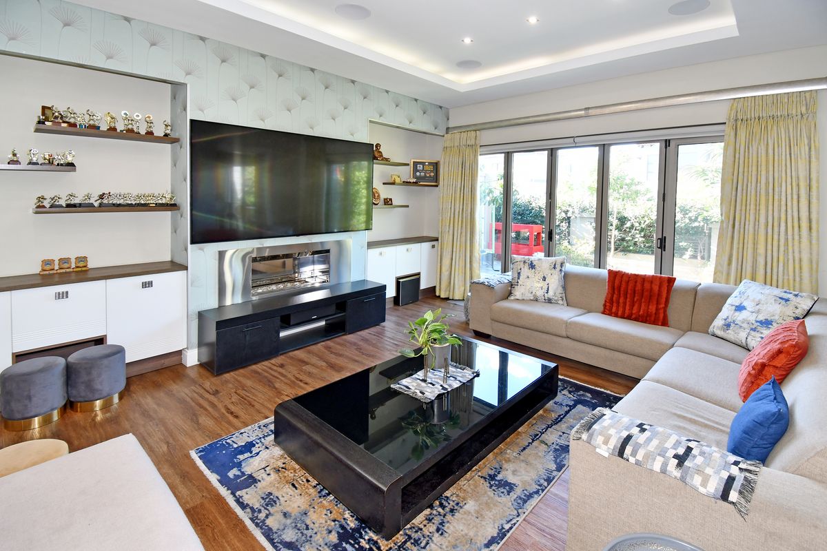 Spacious living room featuring built-in cabinetry, a modern fireplace, recessed ceiling lighting, and large glass sliding doors opening to the garden.