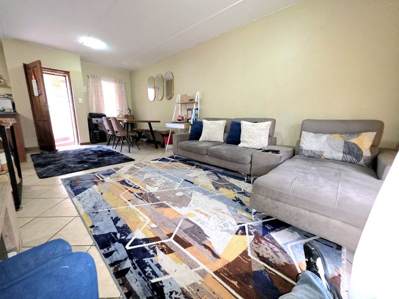 Open plan living and dining area featuring tiled flooring and direct access to an exterior entrance.