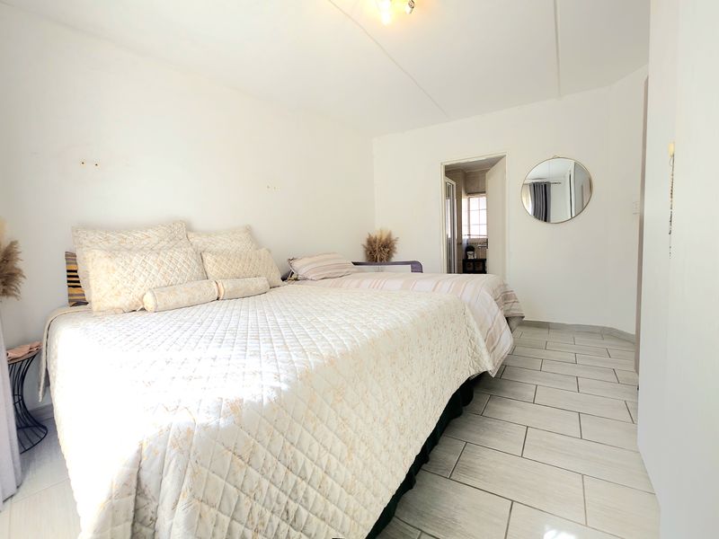 A bedroom featuring tiled flooring and direct access to an en-suite bathroom.