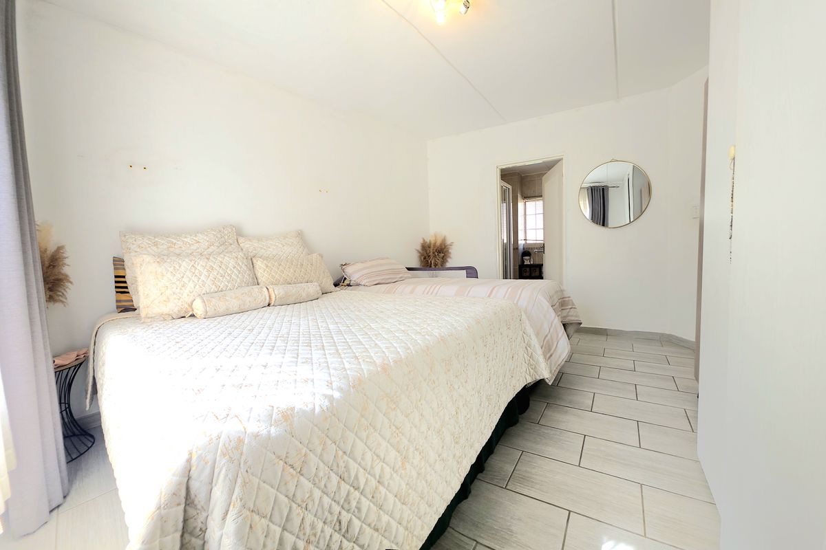 A bedroom featuring tiled flooring and direct access to an en-suite bathroom.