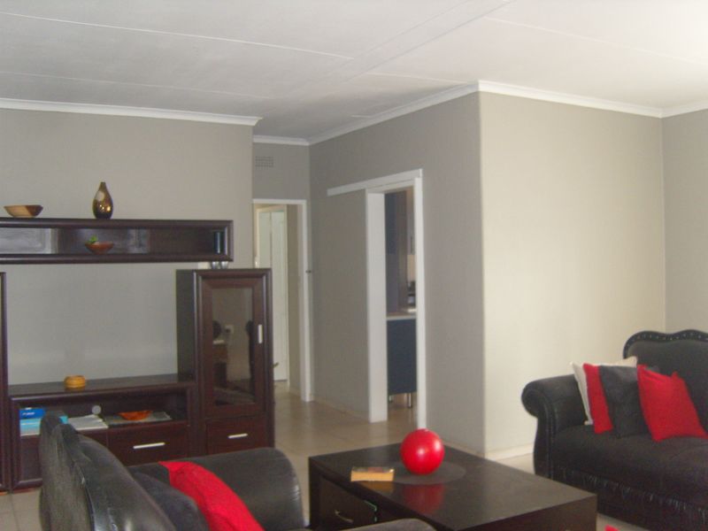 A living room featuring neutral wall tones, tiled flooring, and a sliding door leading to an adjacent space.