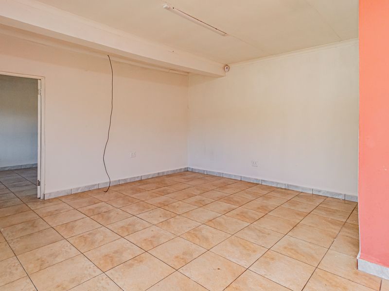 An empty living area featuring ceramic floor tiles and a neutral color palette, ready for personalization and staging.
