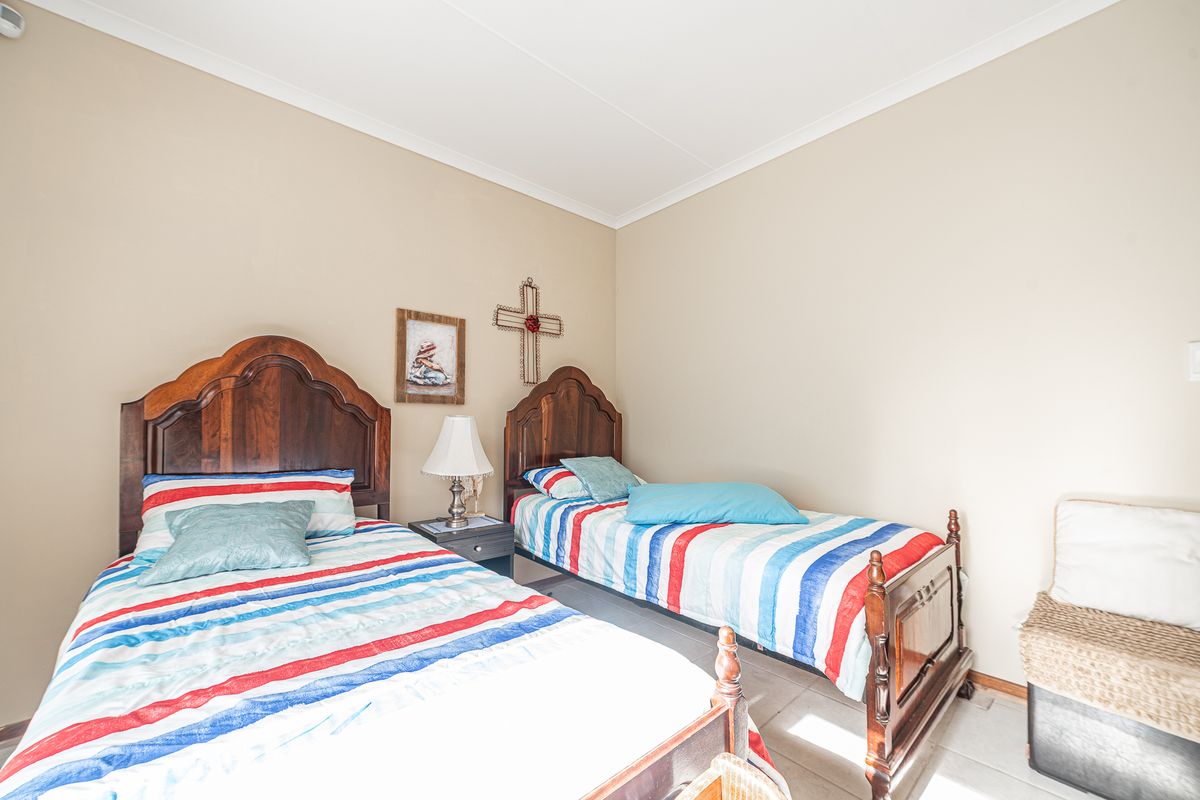 A bedroom featuring tiled flooring and neutral wall finishes, providing a functional space for sleeping arrangements.