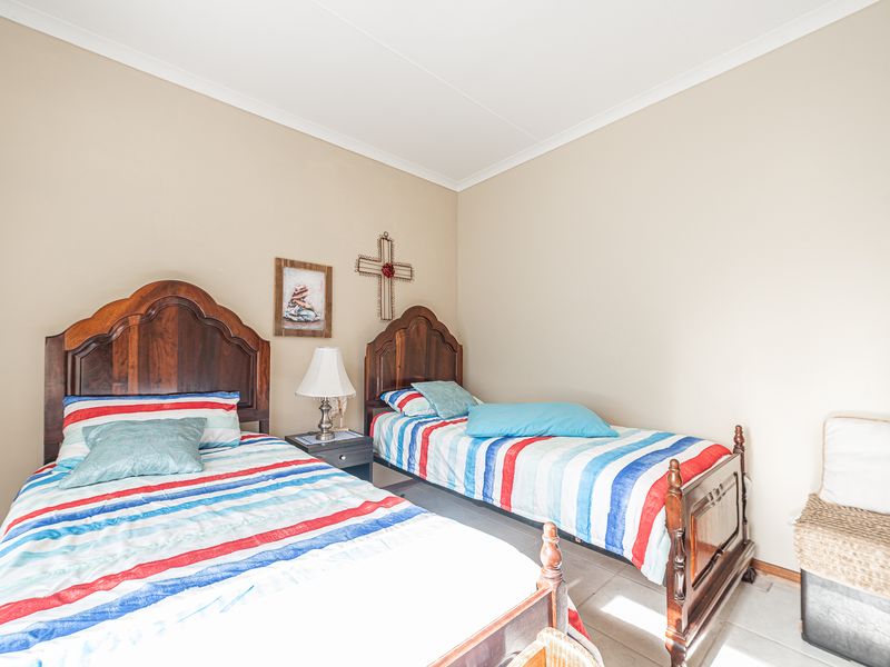 A bedroom featuring tiled flooring and neutral wall finishes, providing a functional space for sleeping arrangements.