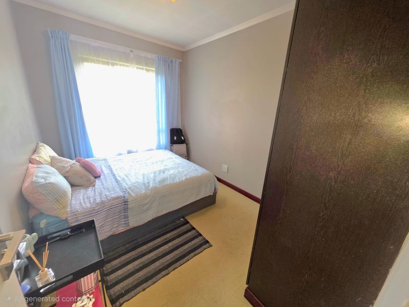 A standard bedroom featuring carpeted flooring, a built-in wardrobe, and a window allowing natural light.