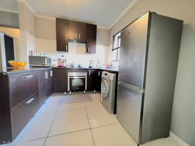 A functional kitchen featuring dark wood cabinetry, granite countertops, built-in oven, and tiled flooring, offering a clean and practical workspace.