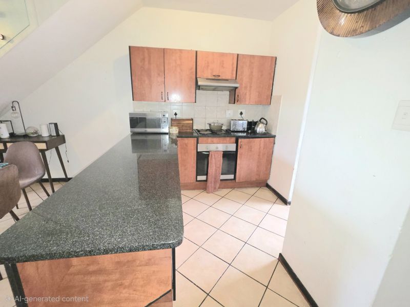 Compact kitchen featuring granite countertops, built-in oven, hob, extractor fan, and laminate cabinetry with tiled flooring.