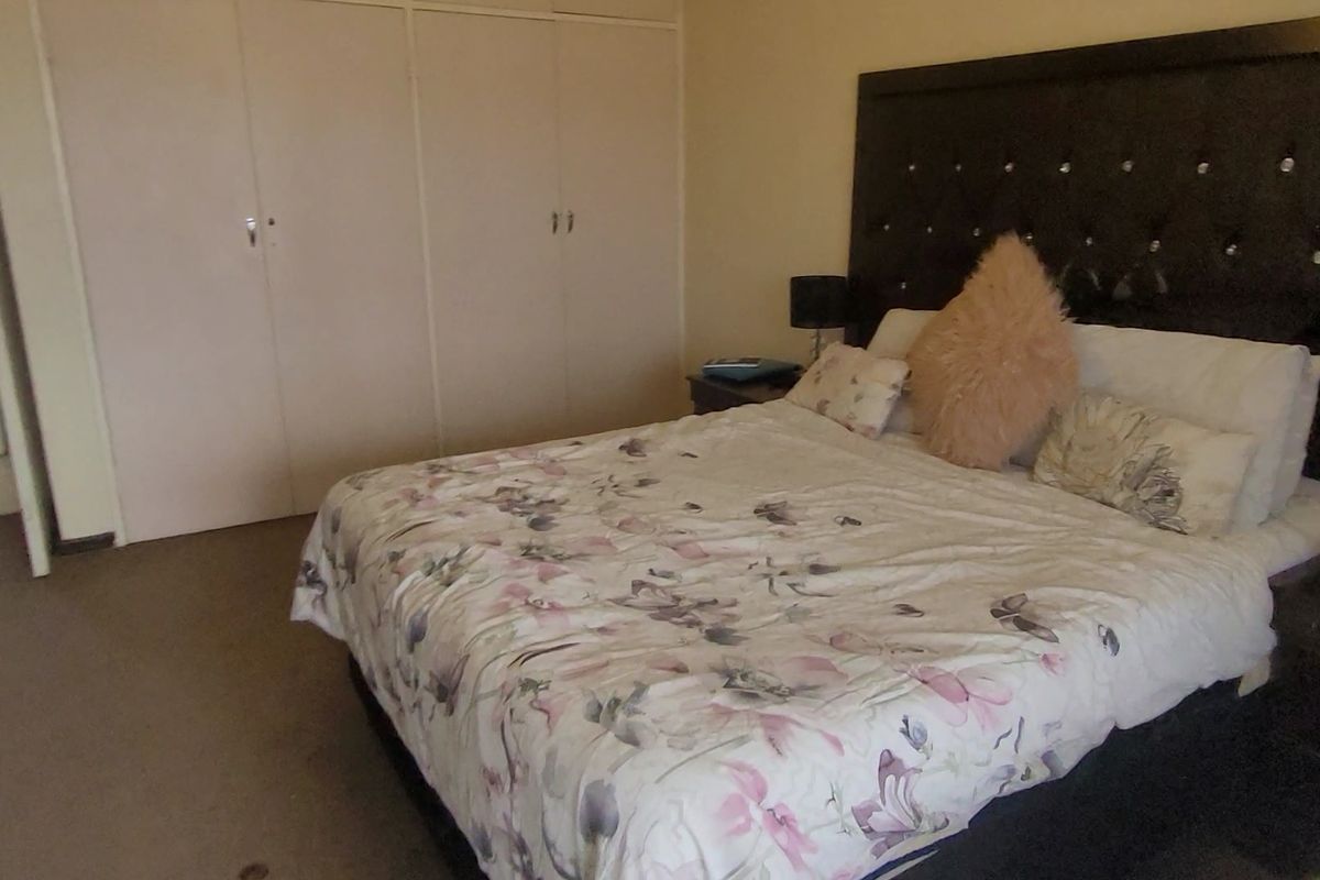 A bedroom featuring built-in cupboards and direct access to an adjoining bathroom.