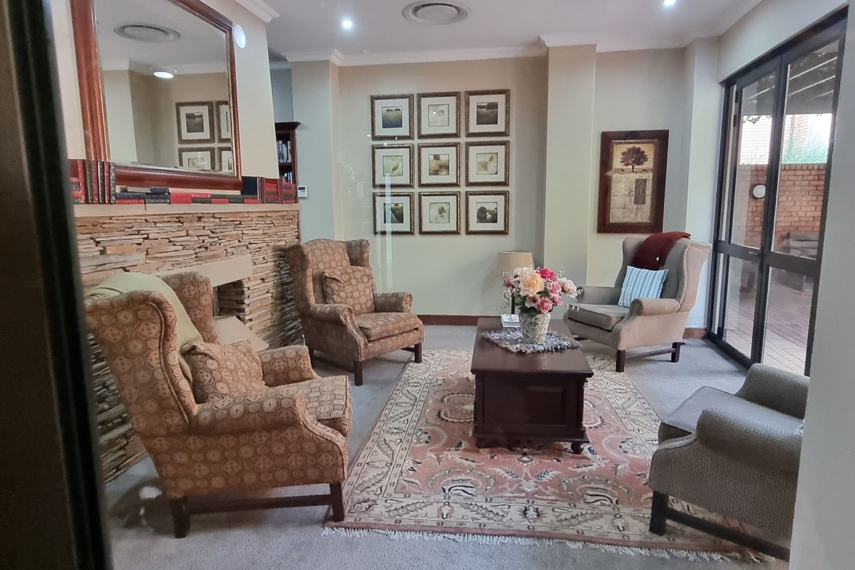 A comfortable living room featuring a stone-clad fireplace, recessed lighting, and large sliding glass doors providing access to the outdoor area.