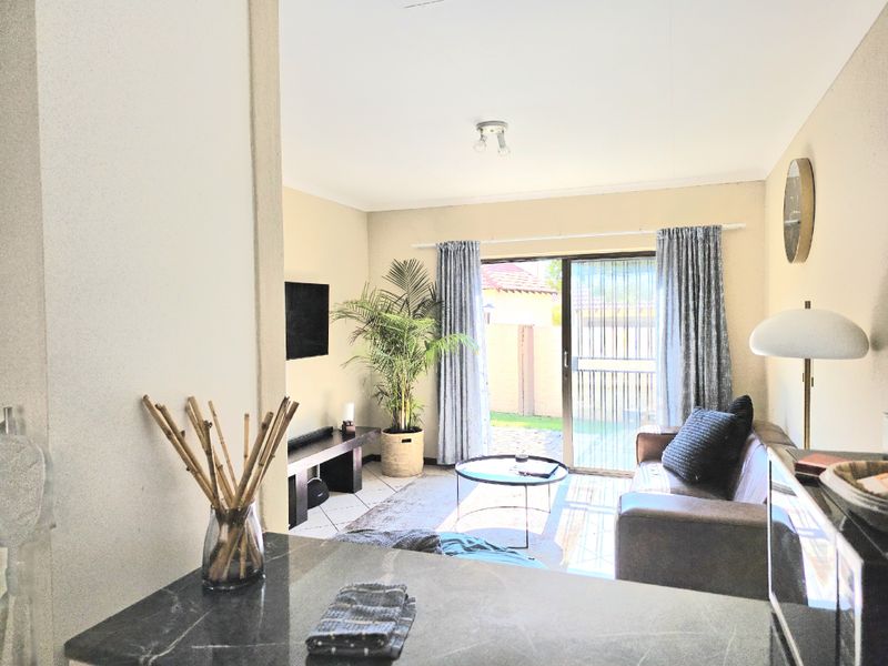 Open plan living area featuring tiled flooring and a sliding glass door providing direct access to the rear patio and garden.