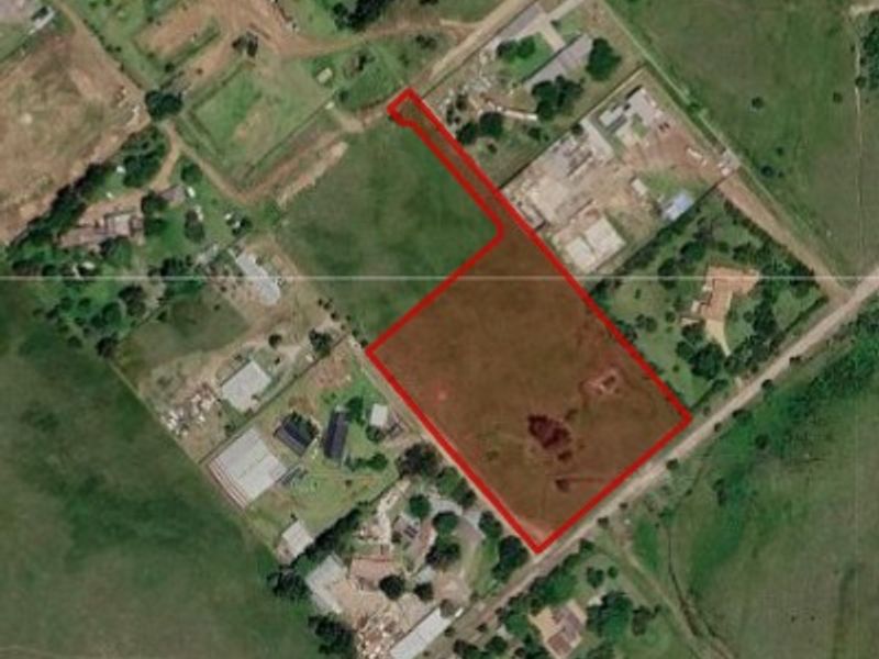 Aerial view of a vacant residential plot with clearly marked boundaries, situated in a semi-rural residential area.