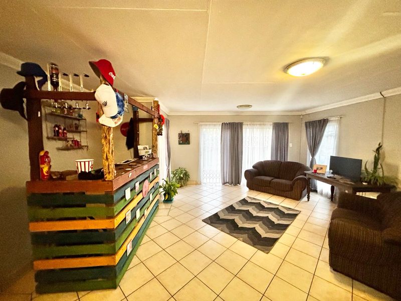 Spacious living area featuring a built-in bar counter, tiled flooring, and sliding glass doors providing access to the exterior.