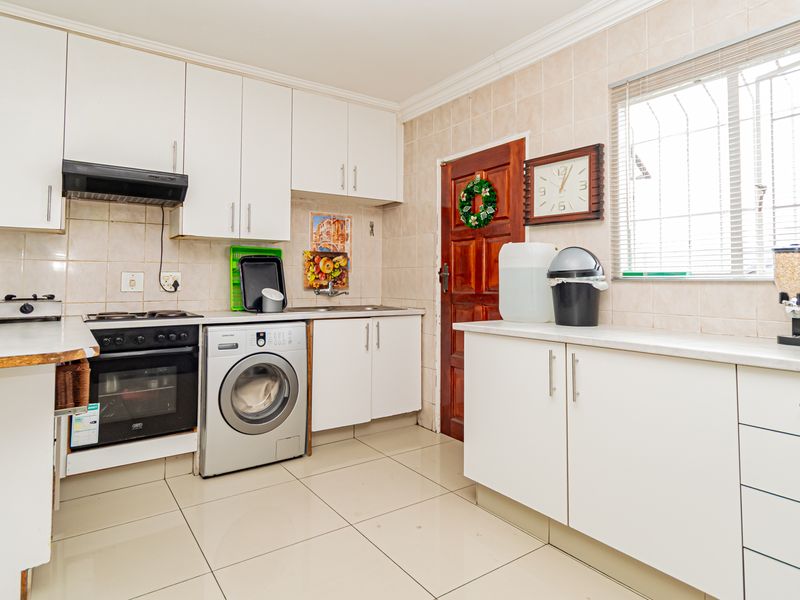 Functional kitchen featuring white cabinetry, tiled backsplash, built-in oven with hob, and tiled flooring, offering a clean and practical workspace.