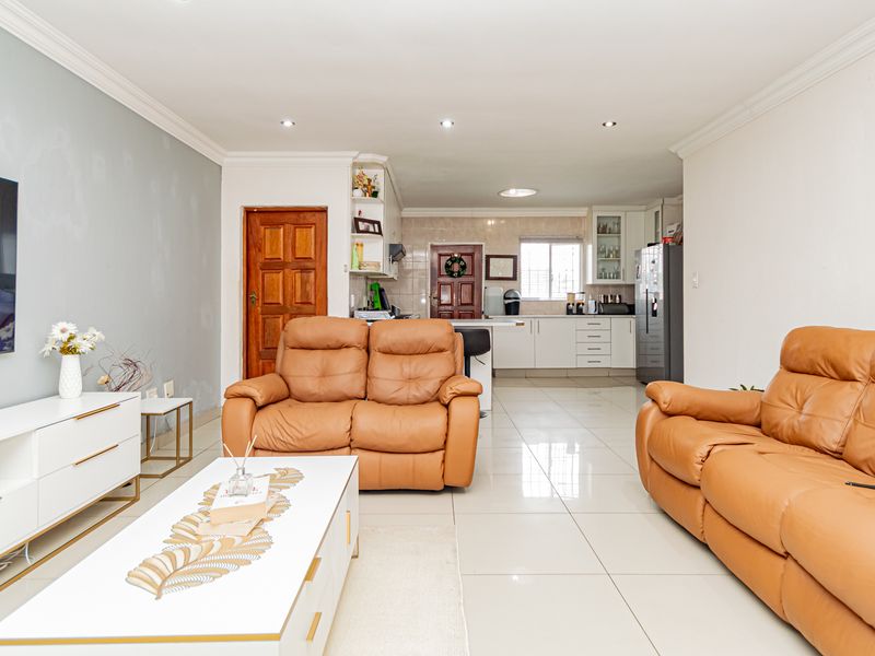 Open-plan living and kitchen area featuring tiled flooring, recessed lighting, and modern cabinetry, offering a functional and connected layout for daily living.