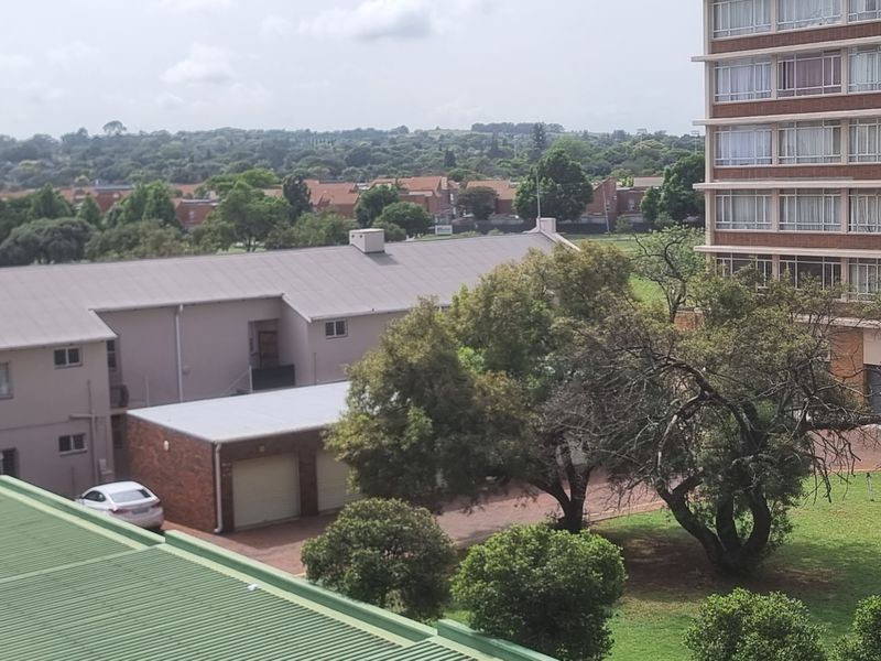 Elevated view overlooking the surrounding residential complex, featuring landscaped garden areas, paved driveways, and neighbouring apartment buildings.