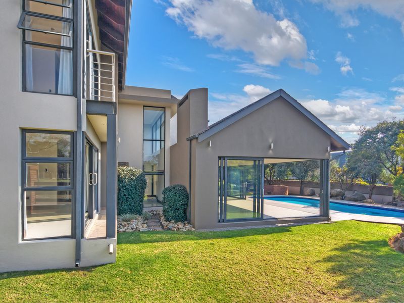 Rear view of a modern multi-story home featuring a swimming pool, paved patio area, and large sliding glass doors opening to the garden.