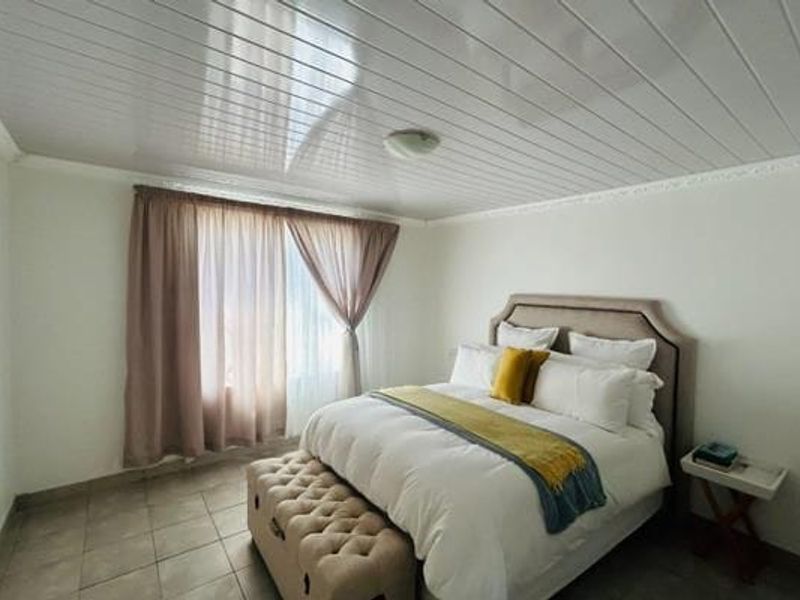 A bedroom featuring tiled flooring and a PVC panelled ceiling, providing a functional and neutral space.
