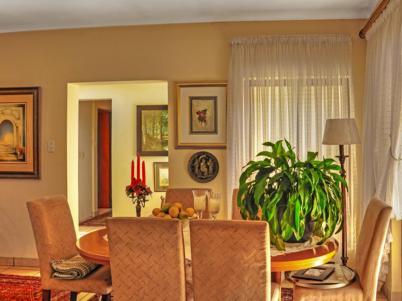 A dining room area featuring tiled flooring and an archway leading to an adjacent hallway.