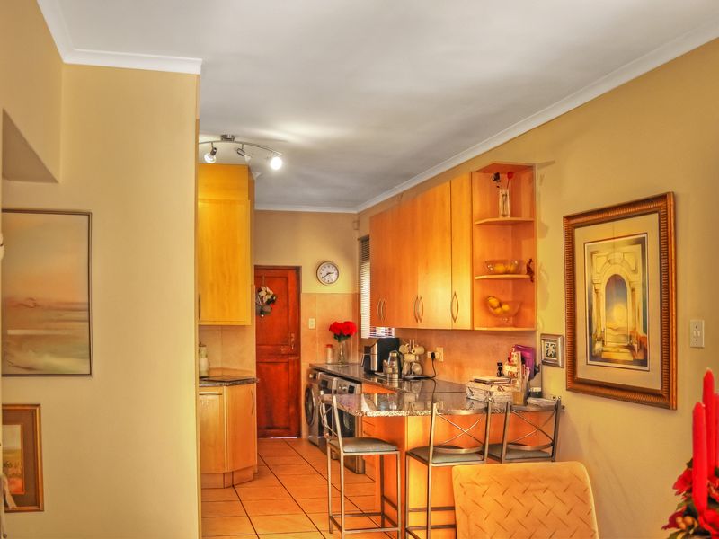 A functional kitchen featuring light wood cabinetry, granite countertops, a breakfast bar, and tiled flooring, providing a practical layout for daily meal preparation.