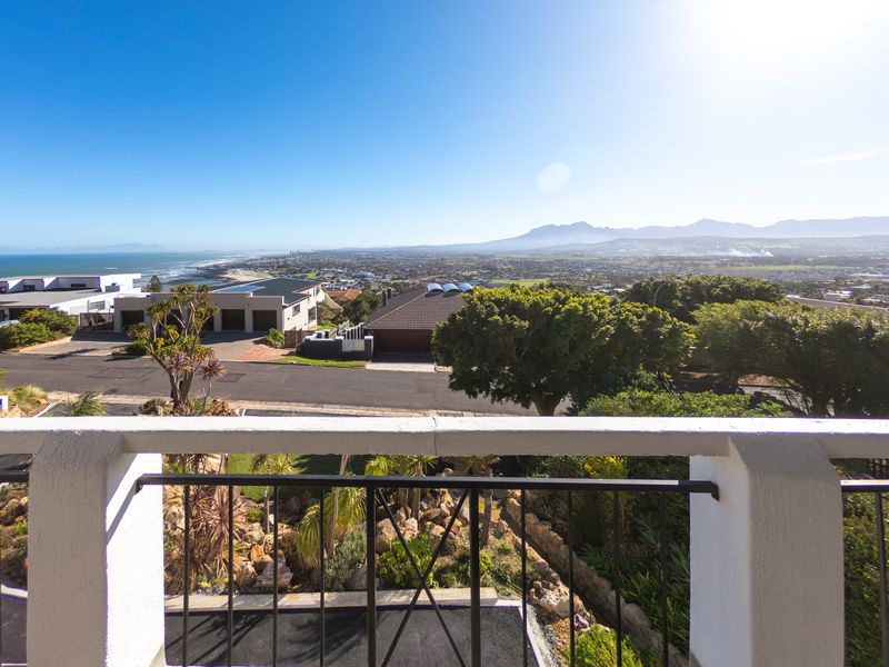 Elevated balcony offering expansive panoramic views of the coastline, surrounding neighbourhood, and distant mountain ranges.