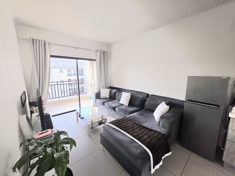 Open plan living area featuring tiled flooring and direct access to a private balcony through sliding glass doors.