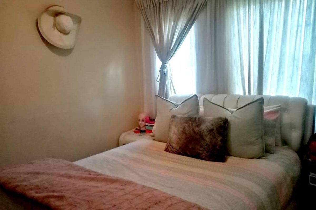 A cozy bedroom featuring neutral wall tones and window treatments, providing a comfortable and private sleeping space.