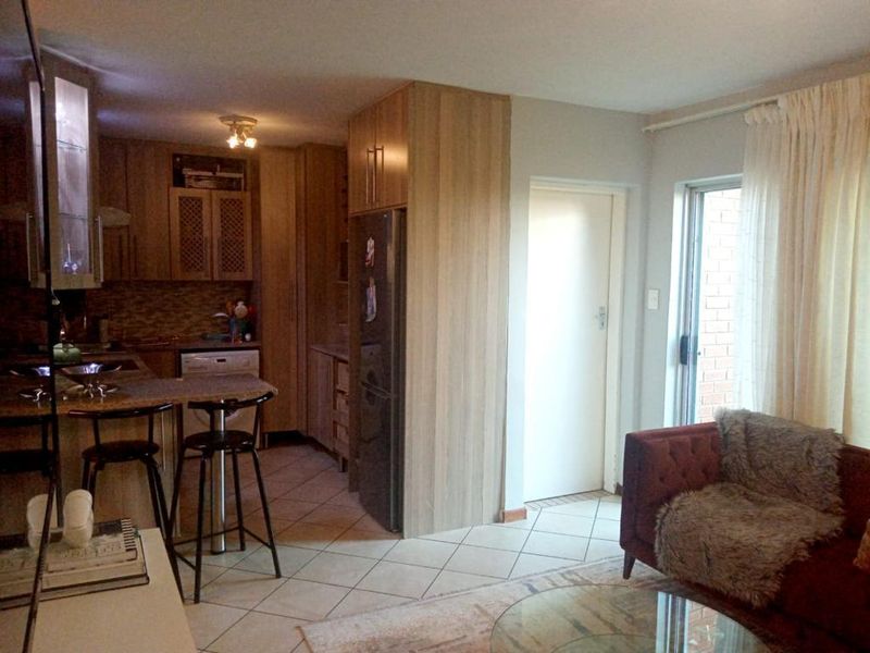 Open plan living area featuring a kitchen with laminate cabinetry, granite countertops, and tiled flooring, with direct access to an outdoor space.