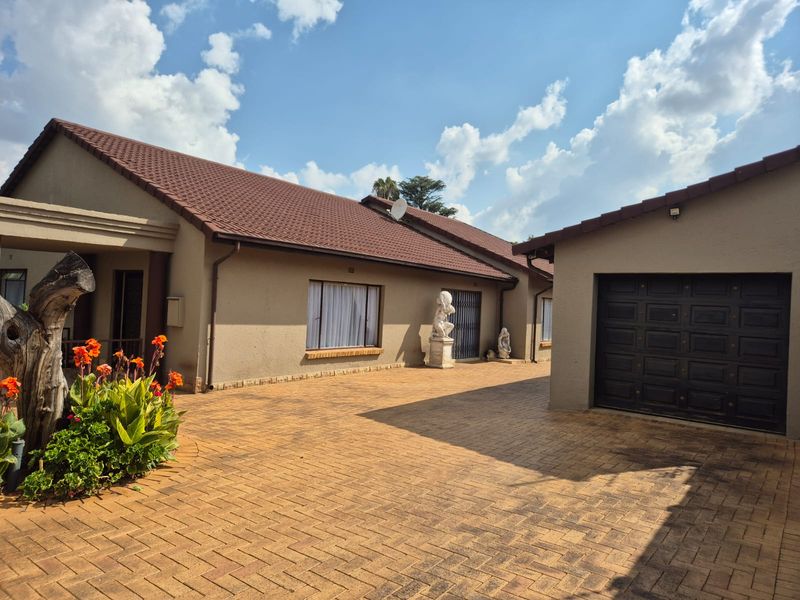 Front exterior view of the house featuring a paved driveway, tiled roof, and integrated garage.