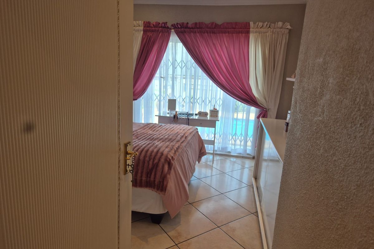 A bedroom featuring tiled flooring, recessed ceiling lighting, a ceiling fan, and a security gate leading to an outdoor area.