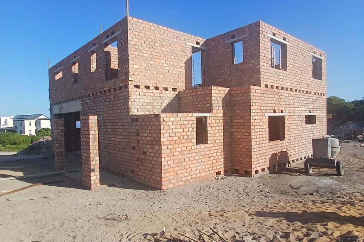A double-storey residential property currently under construction, featuring exposed brickwork and structural framing for a future home.
