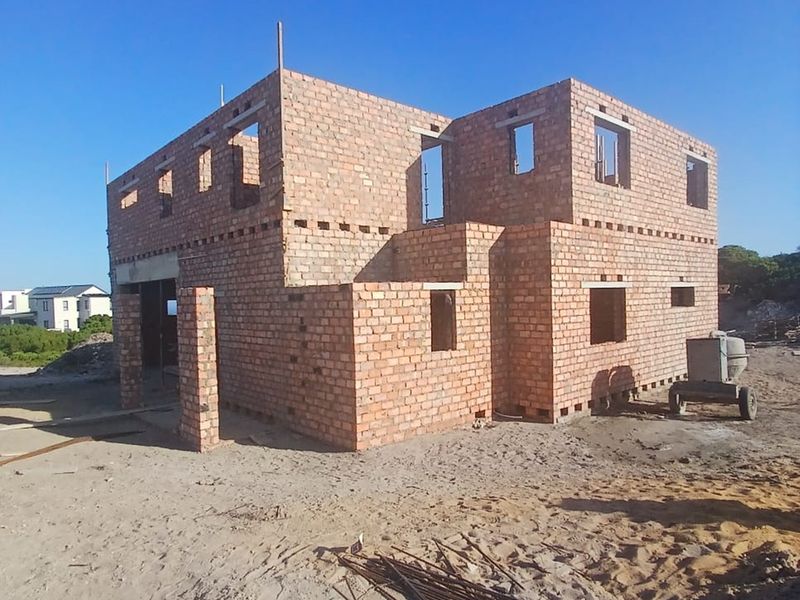 A double-storey residential property currently under construction, featuring exposed brickwork and structural framing for a future home.