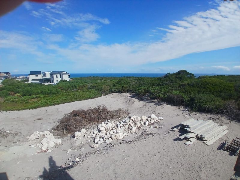 Elevated view overlooking a coastal landscape with natural vegetation and distant ocean horizon.