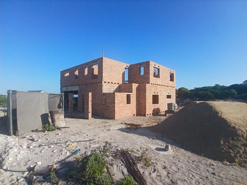 A residential property currently under construction, showing the primary brick structure and shell in an early development phase.