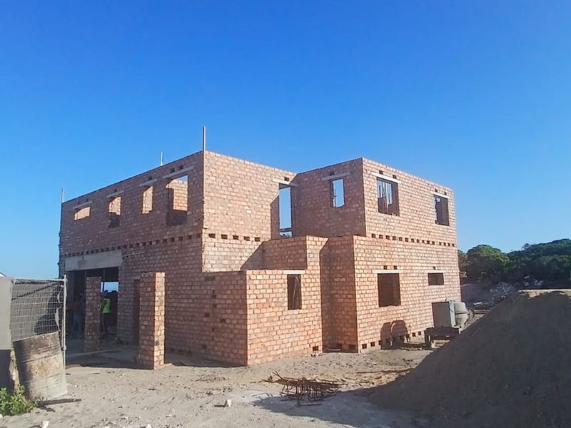 A two-story residential property currently under construction, featuring exposed brickwork and structural masonry in the early stages of development.