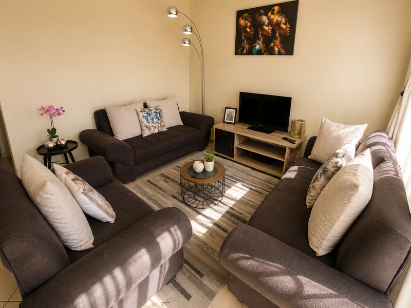 A comfortable and well-lit living room featuring neutral wall tones and durable tiled flooring, creating a welcoming space for relaxation.