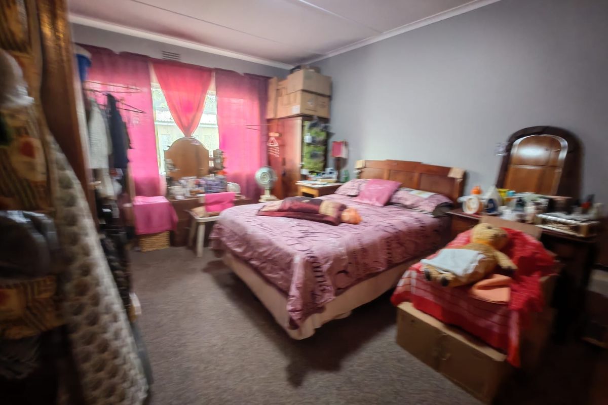 A bedroom featuring carpeted flooring and a window with natural light, providing a functional space for rest.