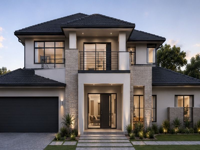 Modern double-story residential facade featuring stone cladding, a balcony with metal railings, a double garage, and professionally landscaped front garden.