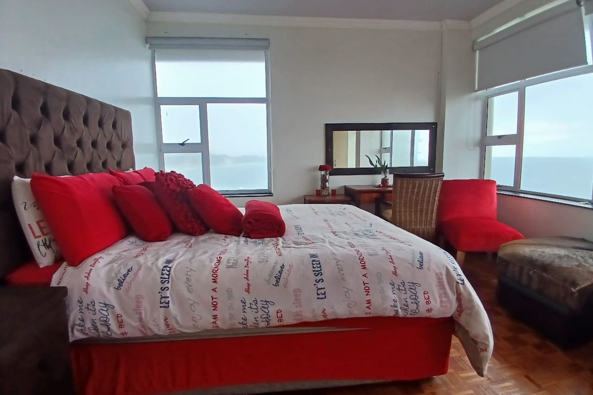 Spacious bedroom featuring parquet flooring, large windows with roller blinds, and a coved ceiling, offering natural light and views.