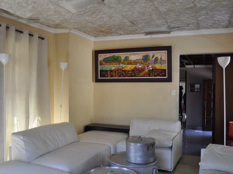 A living room featuring a textured ceiling, neutral wall tones, and a doorway leading to an adjacent interior space.